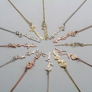 Gold-tone flower name necklace with small floral charm and delicate script pendant chain