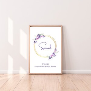 Framed birth announcement poster with gold wreath and purple floral accents