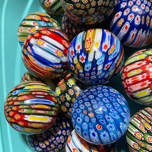 Colorful patterned glass spheres with flower motifs, red blue and striped designs