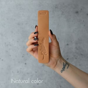 Tan leather bookmark with embossed floral design and MEF text