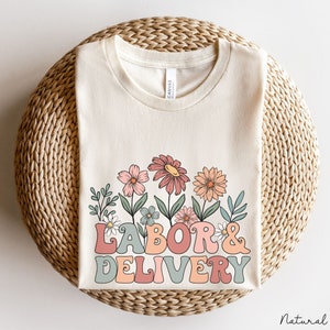 White crewneck t-shirt with pink floral "LABOR & DELIVERY" front graphic