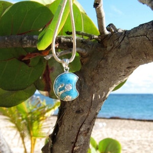 Silver crescent pendant with blue moon/sea enamel, hanging from a loop bail