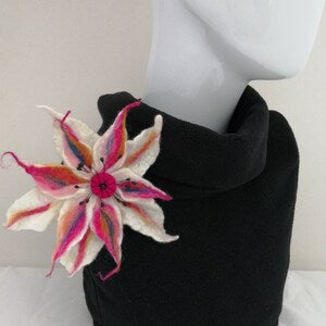 Handmade felt flower brooch with pink, blue, and white petals and dark center
