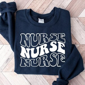 Navy nurse crewneck sweatshirt with bold white “NURSE” text graphic