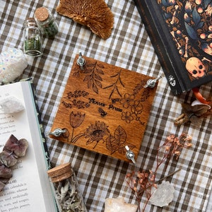 Wooden flower press with leaf and flower engravings and metal corner screws