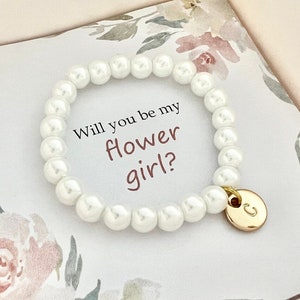 White pearl bracelet with gold heart charm and card text: Will you be my flower girl?