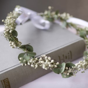 Dried eucalyptus head wreath with small white baby's breath flowers and soft gray ribbon