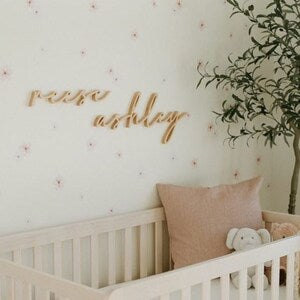 Floral wall decals with small muted pink flowers and cursive lettering for nursery wall