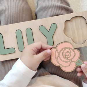 Sage green wooden jigsaw puzzle with large cut-out letters and rose centerpiece