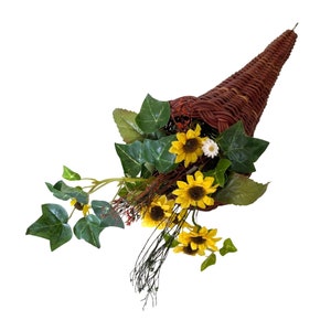 Rustic wicker cornucopia basket with green leaves and yellow daisy-style flowers