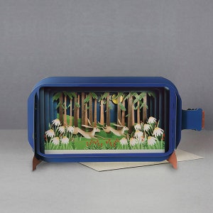 Blue pop-up greeting card with 3D garden scene and white flowers