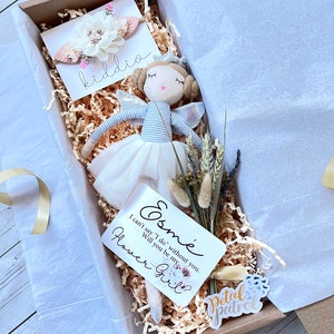 Gift box set with light blue bow headband, plush doll, and decorative tags
