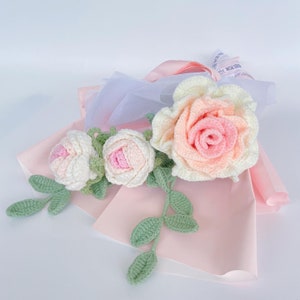 Crochet rose bouquet with pink and white roses and green leaf accents, ribbon-wrapped