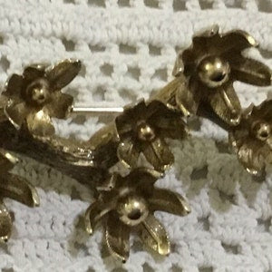 Goldtone leaf brooch with multiple leaf-shaped segments and round accents
