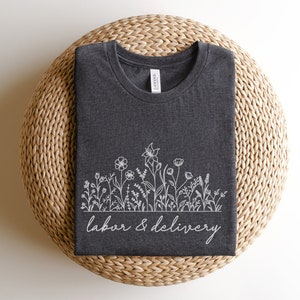 Dark gray T-shirt with white floral line art and 'Labor & delivery' text