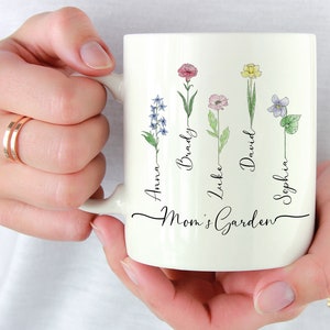 White ceramic mug with floral garden design and cursive Mom's Garden text
