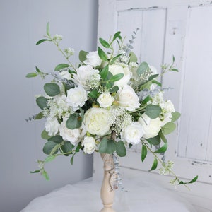 White and sage green wedding table floral centerpiece on pedestal with roses, peonies, greenery