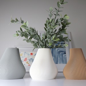 Ribbed dry flower vase with white and tan ceramic-like vases (three shown)