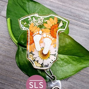 Green badge reel with floral baby romper and footprints charm
