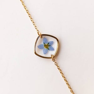 Gold-plated fine chain bracelet with a small forget-me-not flower charm in a bezel