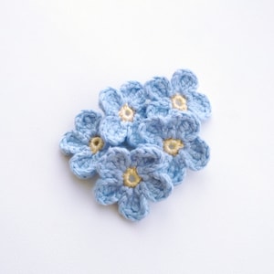 Light blue forget-me-not crochet applique, five layered flowers with yellow centers