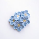Light blue forget-me-not crochet applique, five layered flowers with yellow centers