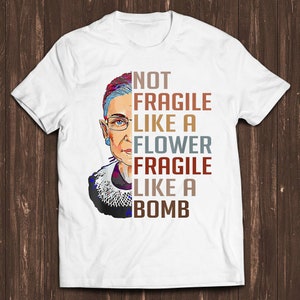 White t-shirt with portrait and stacked text: NOT FRAGILE LIKE A FLOWER BOMB