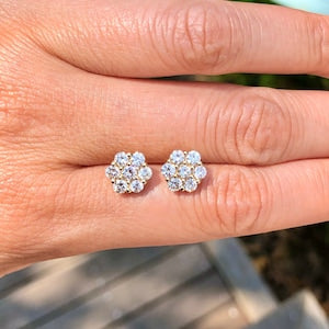 Round-cut moissanite stud earrings with small floral diamond cluster design