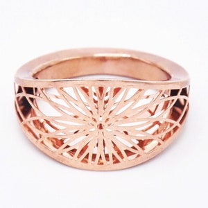 Gold-tone filigree flower ring with lattice chakra-style pattern across the band