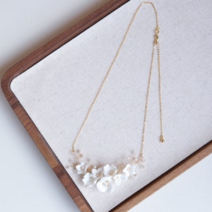 Boho flower bridal necklace with gold chain and white floral pendant clusters