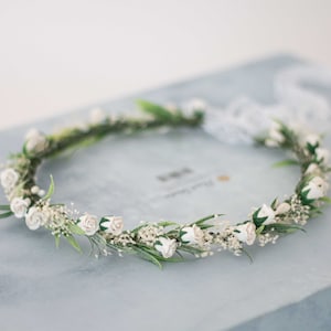 Dried baby's breath floral crown with small white blooms and green leaves