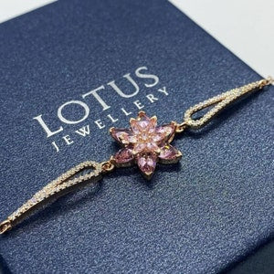 Lotus flower charm bracelet with pink floral pendant, gold-tone chain and clasp