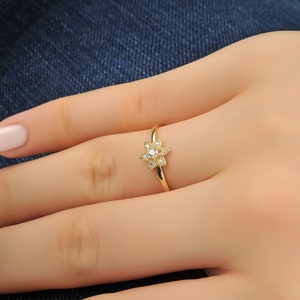 Lotus flower gemstone ring with small clear stone cluster on a slim gold band
