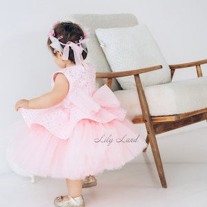 Pink tulle first birthday dress with layered skirt and bow detail