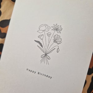 Floral birthday card with black line bouquet and 'Happy Birthday' lettering on white