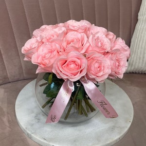 Pink faux rose bubble vase with greenery and decorative gift tag
