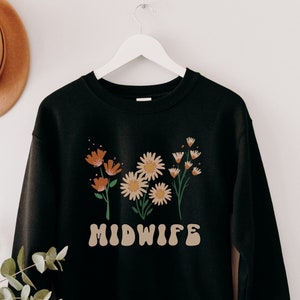 Black sweatshirt with floral print and MIDWIFE text on the front