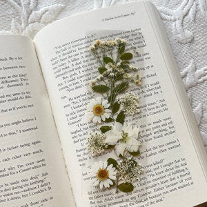 Wildflower bookmark with pressed white daisies and green foliage on a clear backing