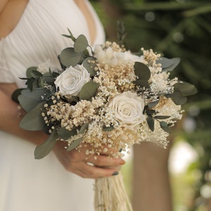 White and green bridal bouquet with roses and eucalyptus-style leaves
