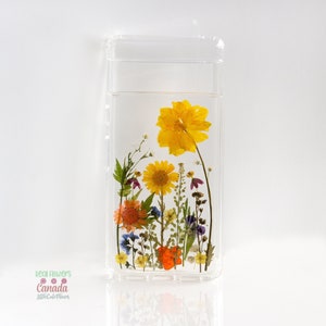 Pressed natural flower phone case cover with yellow, orange, and purple blooms in clear case