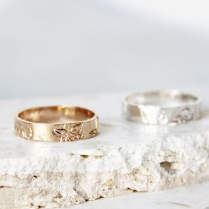 Gold-toned thick floral band ring with birth flower centerpiece and leaf accents