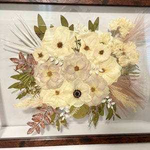 Framed pressed bridal bouquet art with white flowers and small butterfly accents