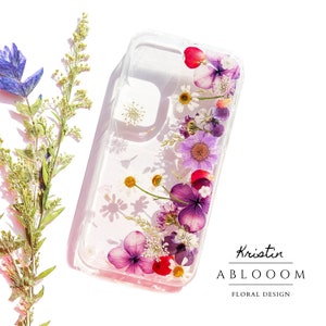 Floral pressed flower phone case with purple and pink blossoms on clear background