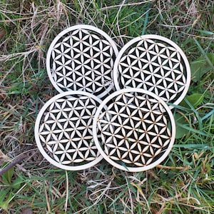 Set of 4 round white coasters with black Flower of Life geometric pattern
