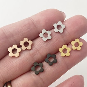 Small flower stud earrings in white/silver, gold, and black with round petals.