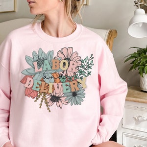 Light pink crewneck sweatshirt with floral 'Labor Delivery' graphic