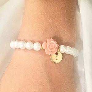 Toddler flower girl bracelet with white beads, pink fabric flower, and heart charm