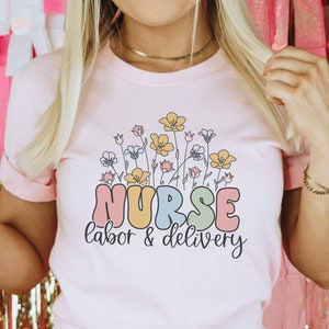 Light pink nurse T-shirt with floral 'NURSE labor & delivery' print