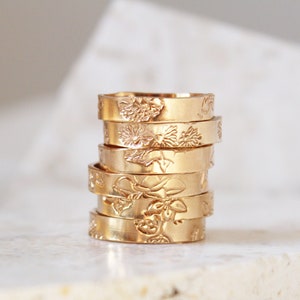 Thick gold ring with engraved floral motifs and patterned band details