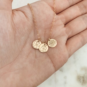 Gold birth flower necklace with three round pendant charms on a chain